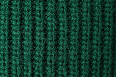 Photo of Texture of green knitted fabric as background, top view