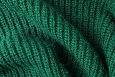 Photo of Texture of green knitted fabric as background, top view