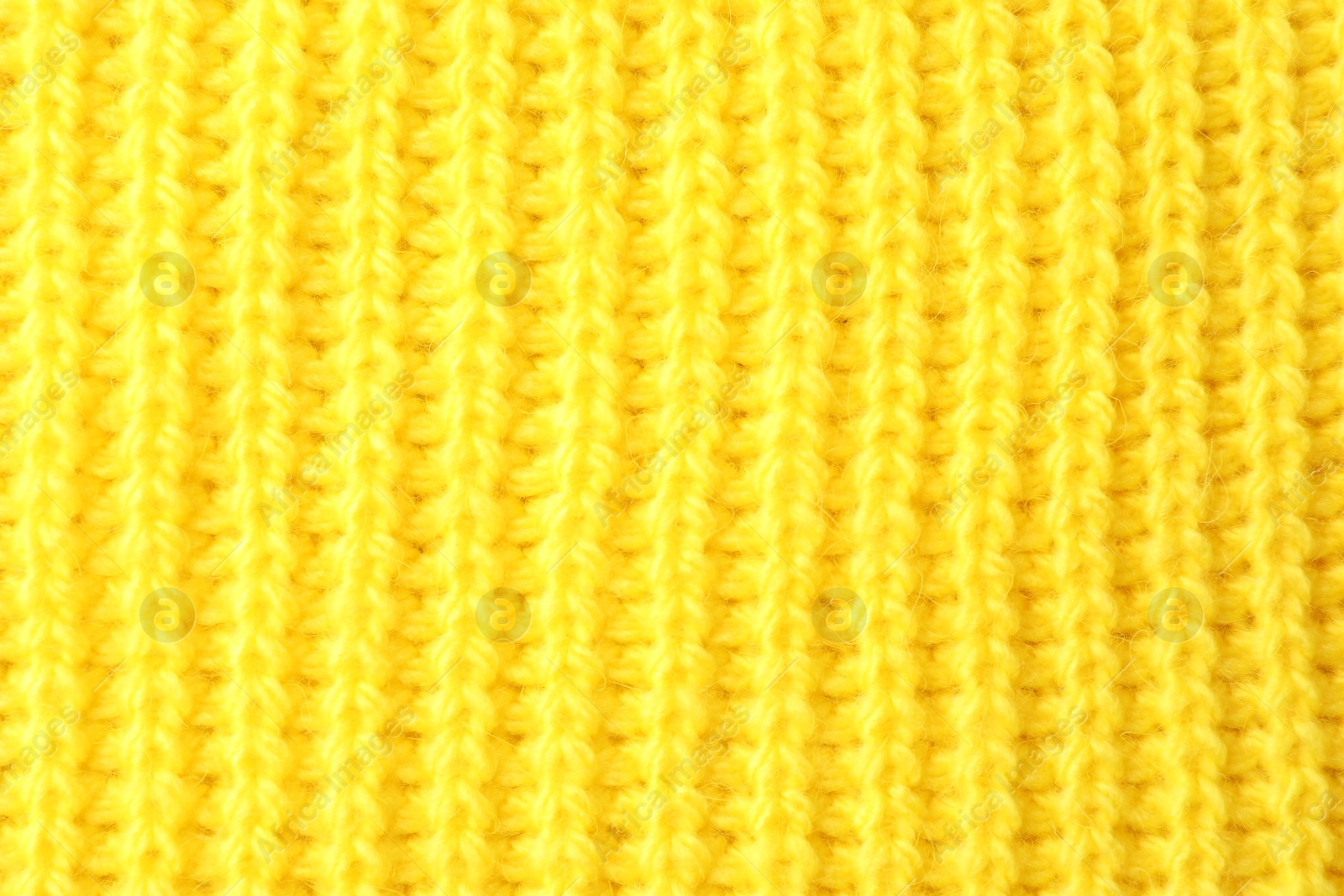 Photo of Texture of yellow knitted fabric as background, top view