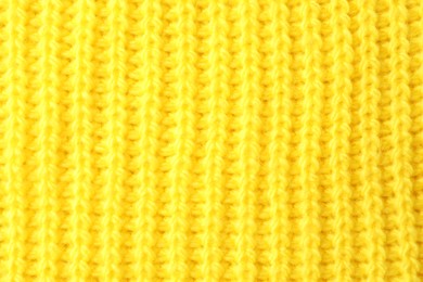 Photo of Texture of yellow knitted fabric as background, top view