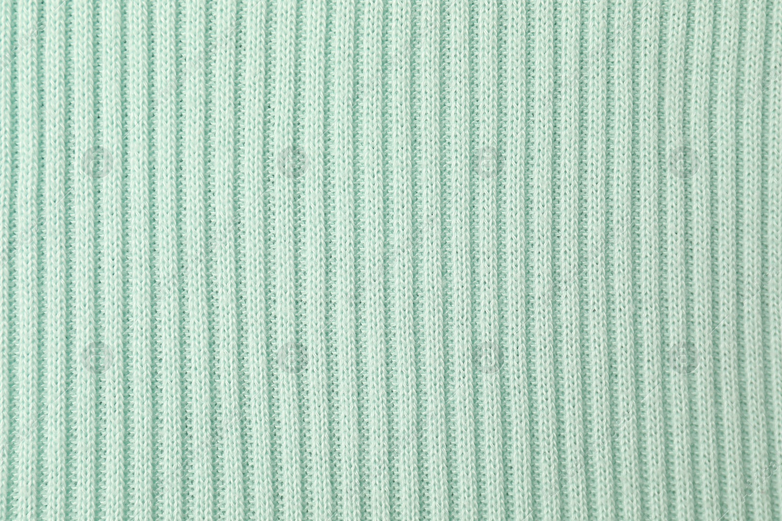 Photo of Texture of light blue knitted fabric as background, top view