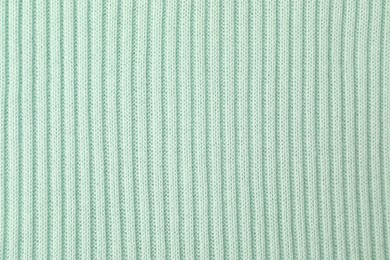 Photo of Texture of light blue knitted fabric as background, top view