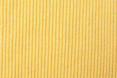 Photo of Texture of light yellow knitted fabric as background, top view