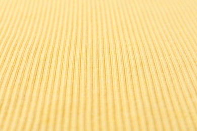 Photo of Texture of light yellow knitted fabric as background, closeup