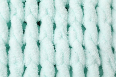 Photo of Texture of light blue knitted fabric as background, top view