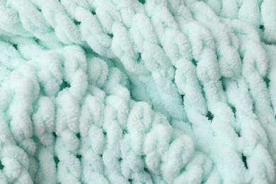 Photo of Texture of light blue knitted fabric as background, top view