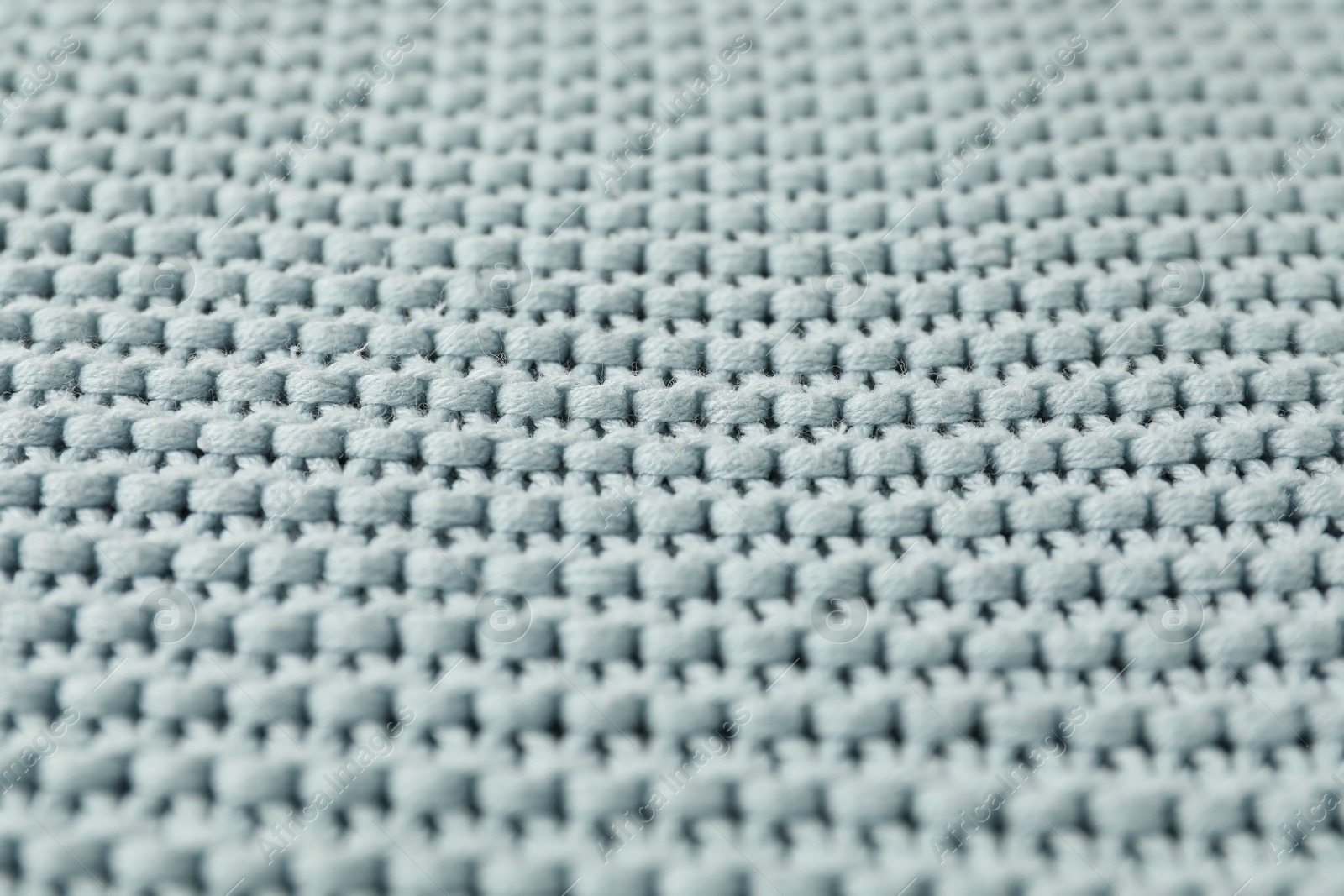 Photo of Texture of light blue knitted fabric as background, closeup