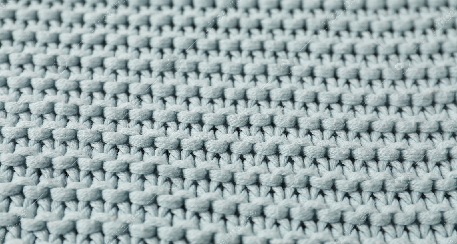 Photo of Texture of light blue knitted fabric as background, closeup