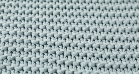 Texture of light blue knitted fabric as background, closeup