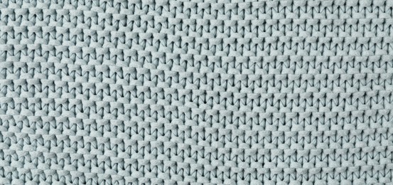 Photo of Texture of light blue knitted fabric as background, top view