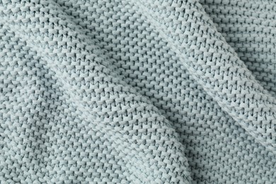 Photo of Texture of light blue knitted fabric as background, top view