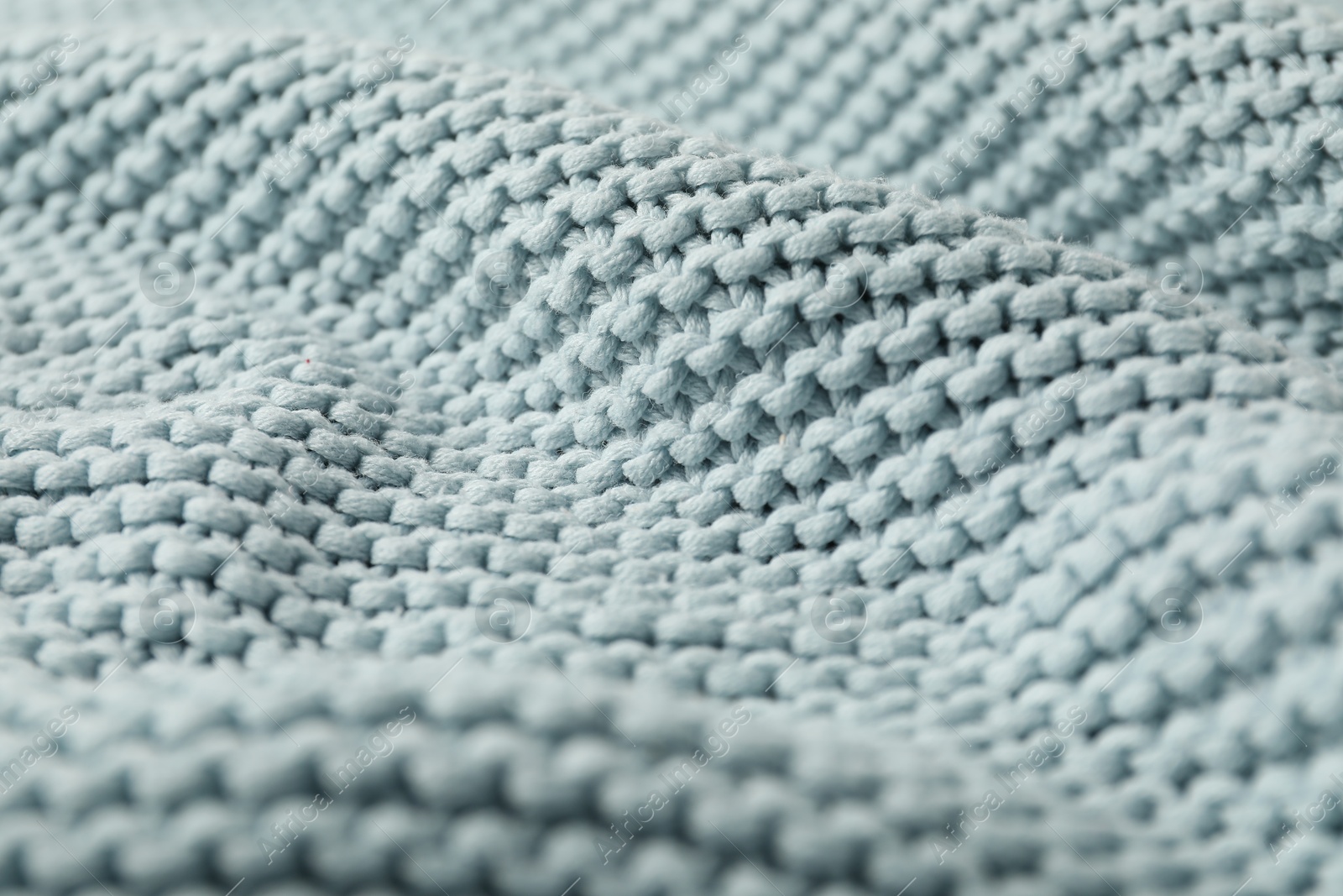 Photo of Texture of light blue knitted fabric as background, closeup