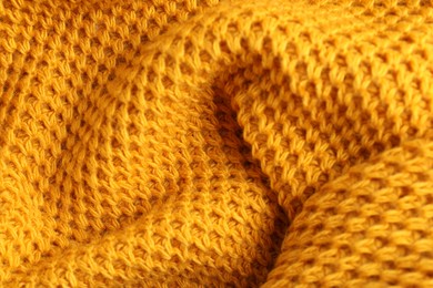 Texture of orange knitted fabric as background, closeup