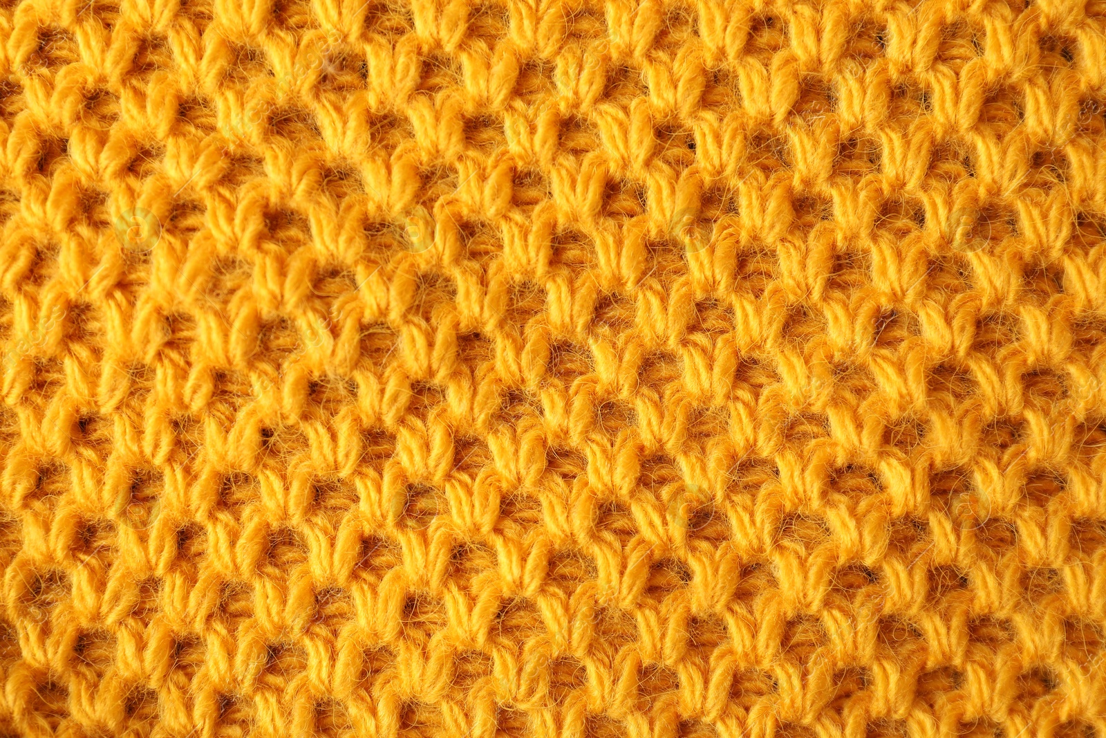 Photo of Texture of orange knitted fabric as background, top view