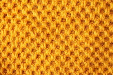 Photo of Texture of orange knitted fabric as background, top view