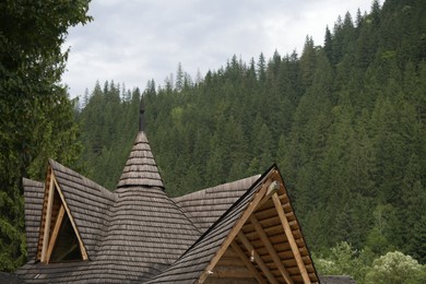 Photo of Beautiful building with wooden roof in mountains, closeup