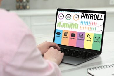 Image of Payroll data. Woman working on laptop at table, closeup