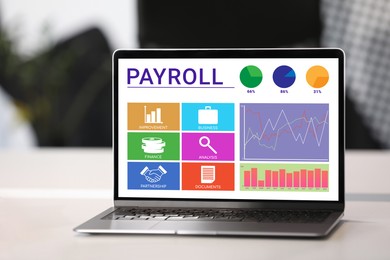 Image of Laptop with payroll data on screen on table