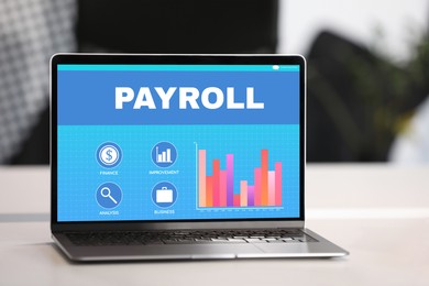 Image of Laptop with payroll data on screen on table