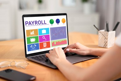 Image of Payroll data. Woman working on laptop at table, closeup