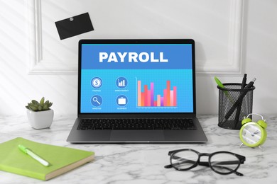 Laptop with payroll data on screen on table