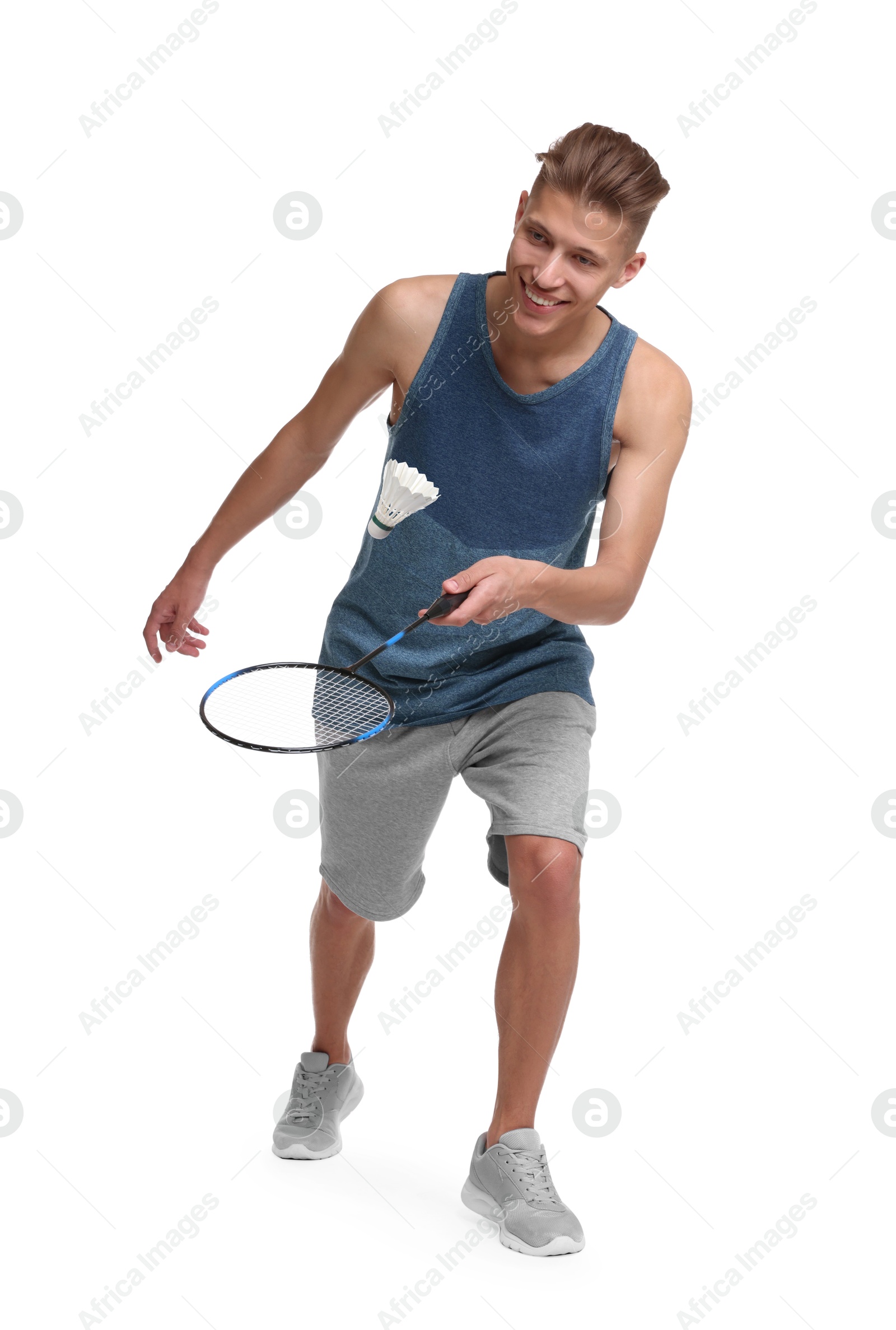 Image of Young man playing badminton with racket and feather shuttlecock on white background