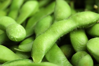 Fresh edamame pods as background, closeup view