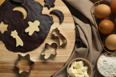 Photo of Raw dough, cookie cutters and ingredients on table, top view