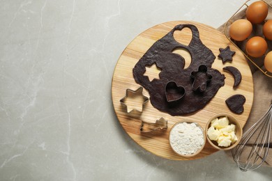 Photo of Raw dough, cookie cutters and ingredients on grey marble table, top view. Space for text