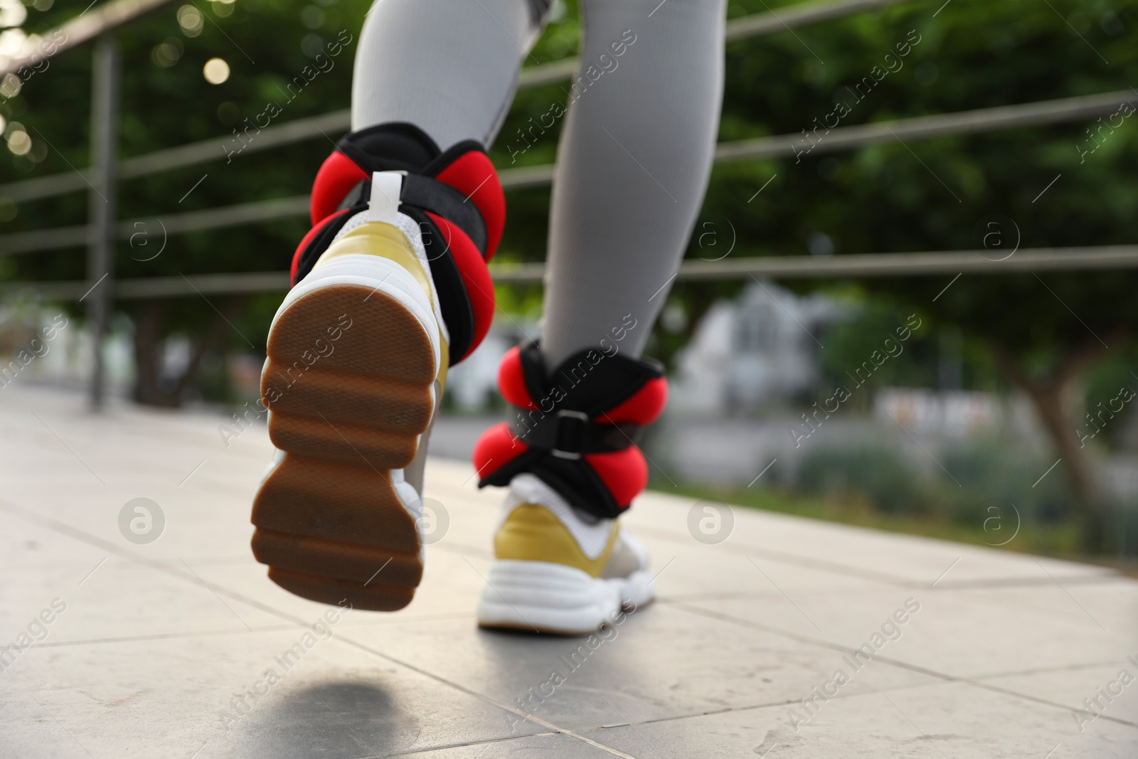 Photo of Woman with ankle weights walking outdoors, closeup