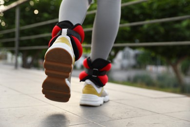 Photo of Woman with ankle weights walking outdoors, closeup