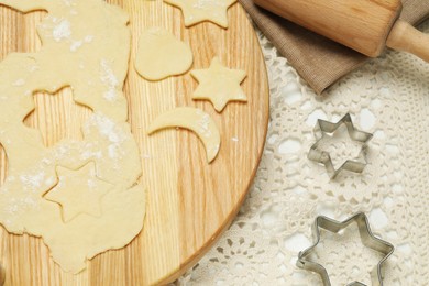 Photo of Raw dough and cookie cutters on white table, above view