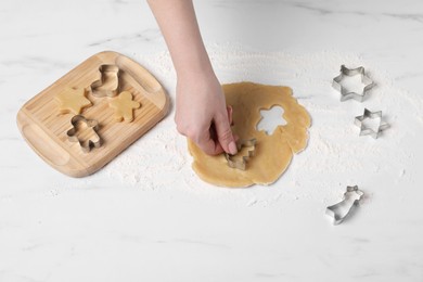 Photo of Woman making cookies with cutters at white marble table, closeup