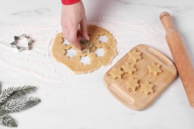 Photo of Woman making cookies with cutters at white marble table, closeup