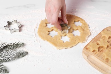 Woman making cookies with cutters at white marble table, closeup