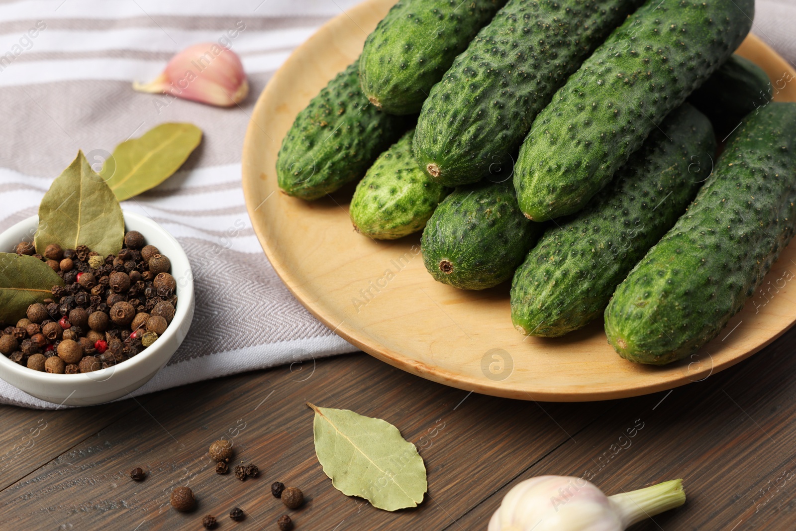 Photo of Fresh green cucumbers and spices on wooden table