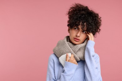 Cold symptom. Young woman with tissue on pink background