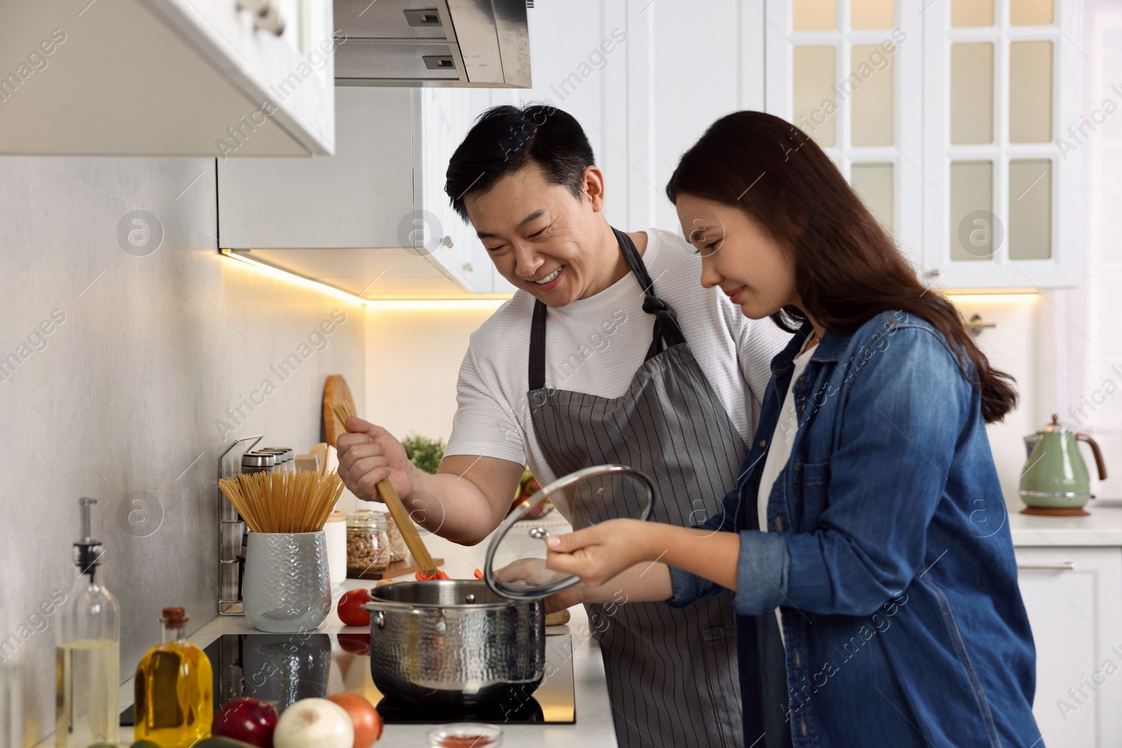 Photo of Happy lovely couple cooking together in kitchen