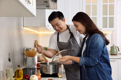 Happy lovely couple cooking together in kitchen