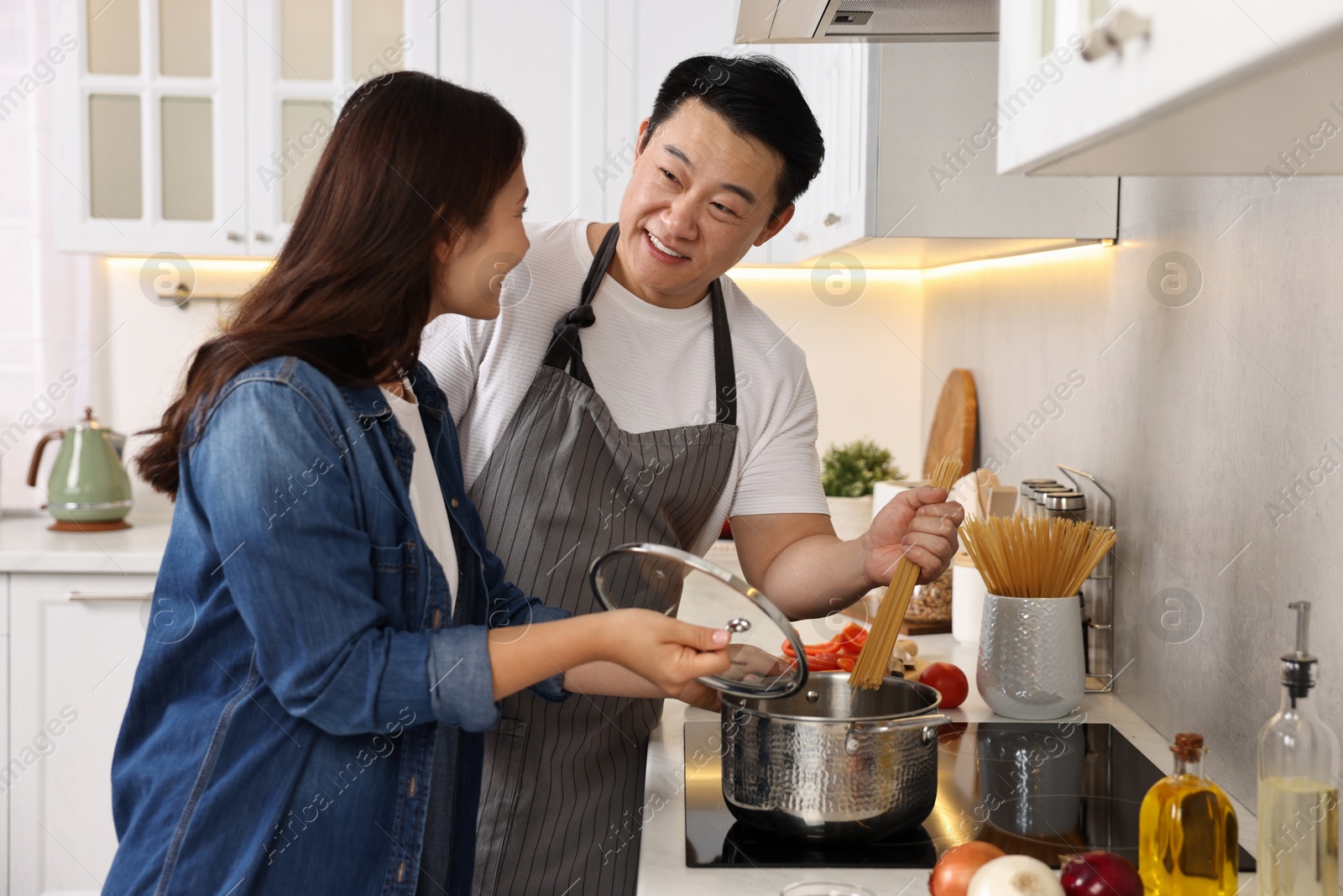 Photo of Happy lovely couple cooking together in kitchen