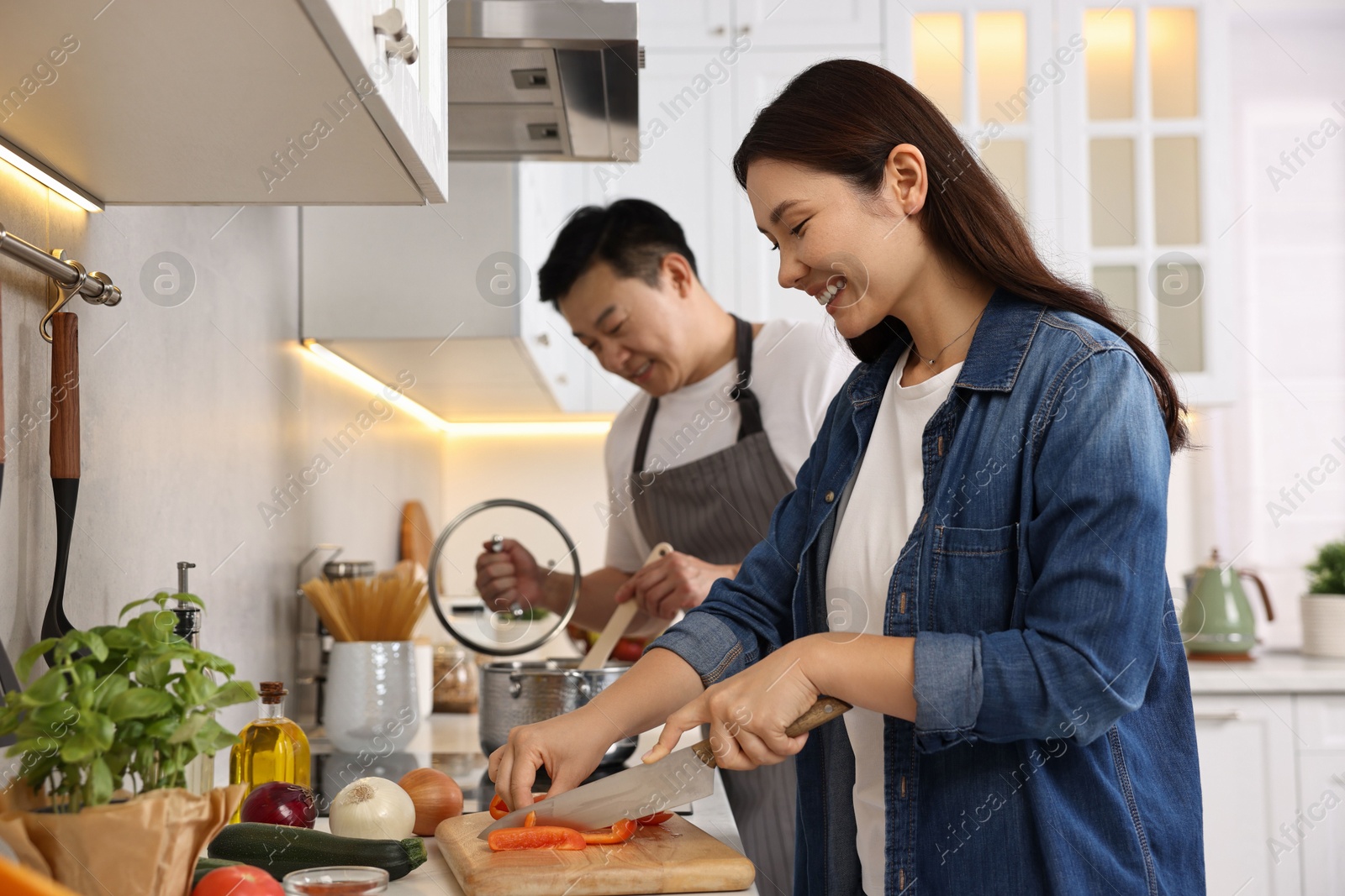 Photo of Happy lovely couple cooking together in kitchen