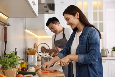 Happy lovely couple cooking together in kitchen