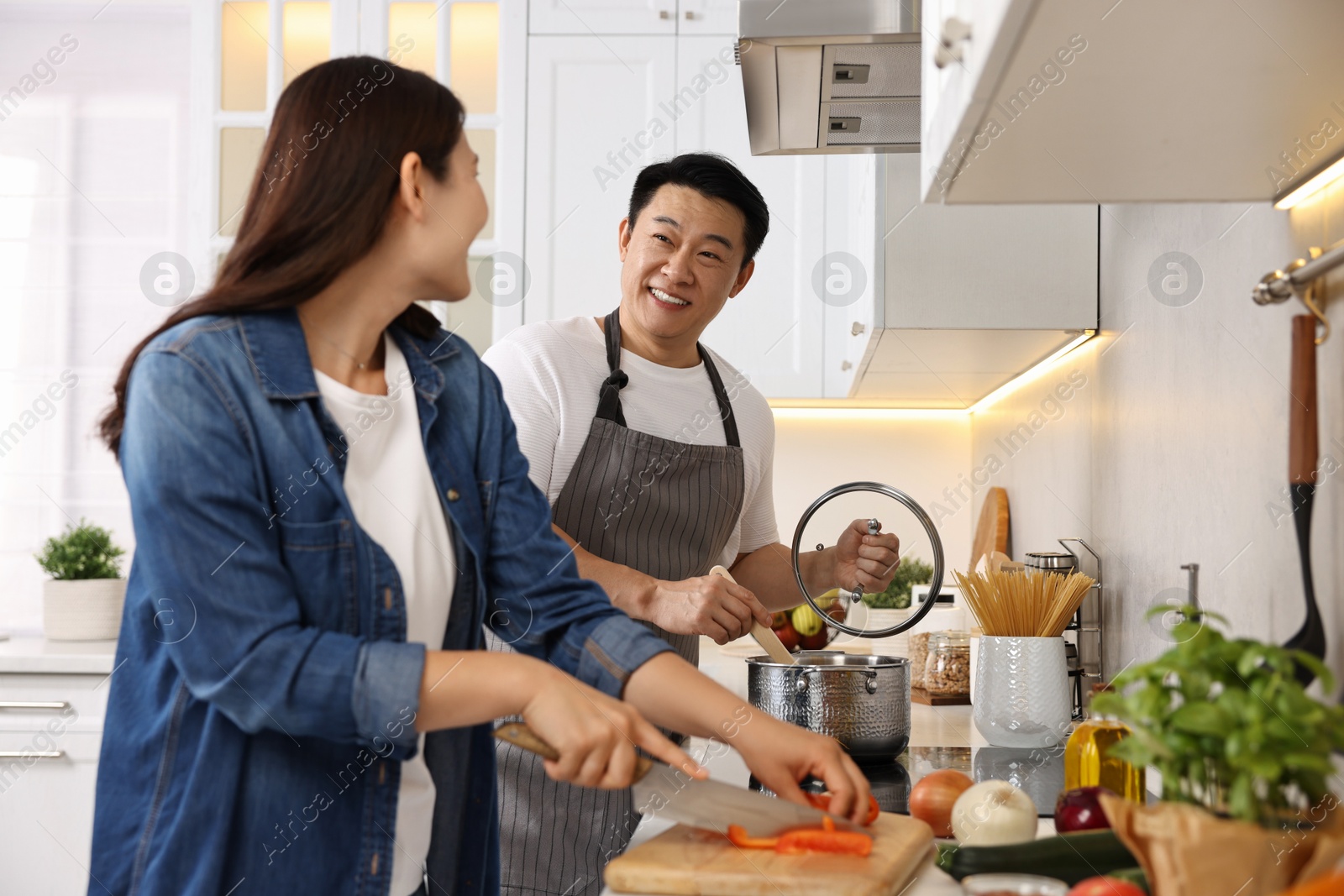 Photo of Happy lovely couple cooking together in kitchen