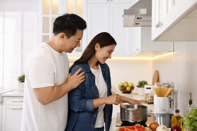 Photo of Happy lovely couple cooking together in kitchen