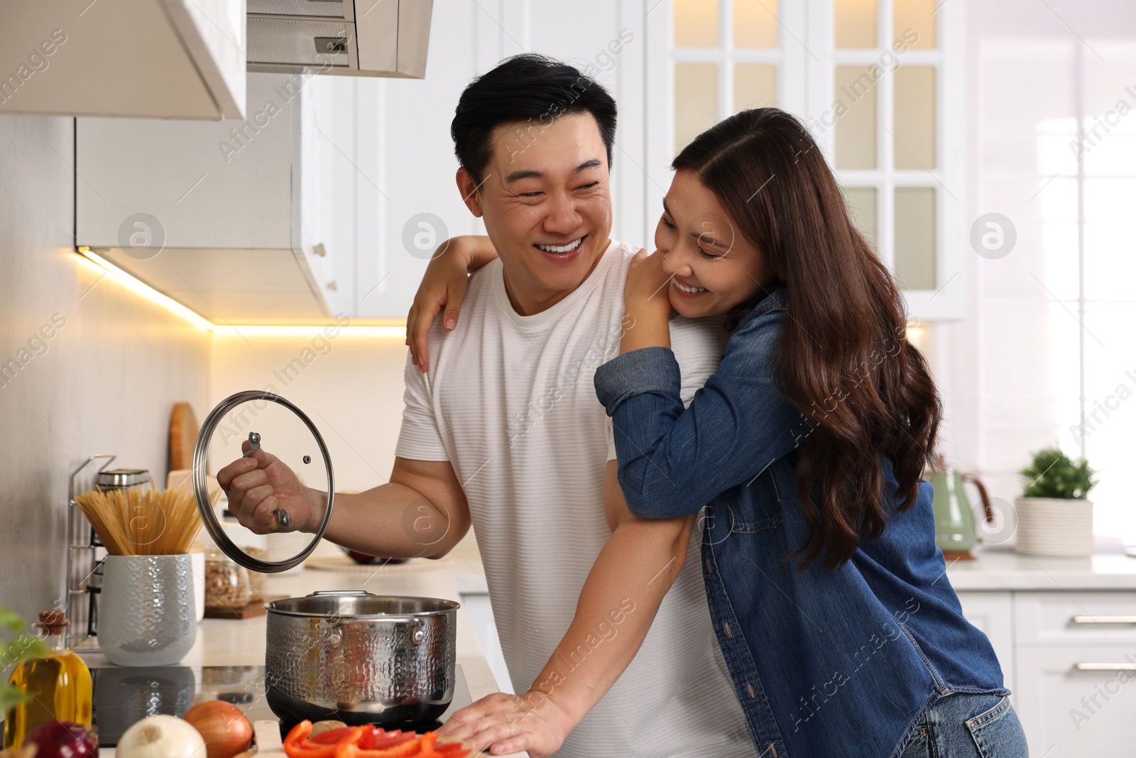 Photo of Happy lovely couple cooking together in kitchen