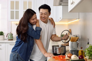 Photo of Happy lovely couple cooking together in kitchen