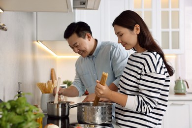 Happy lovely couple cooking together in kitchen