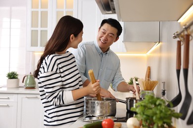 Photo of Happy lovely couple cooking together in kitchen