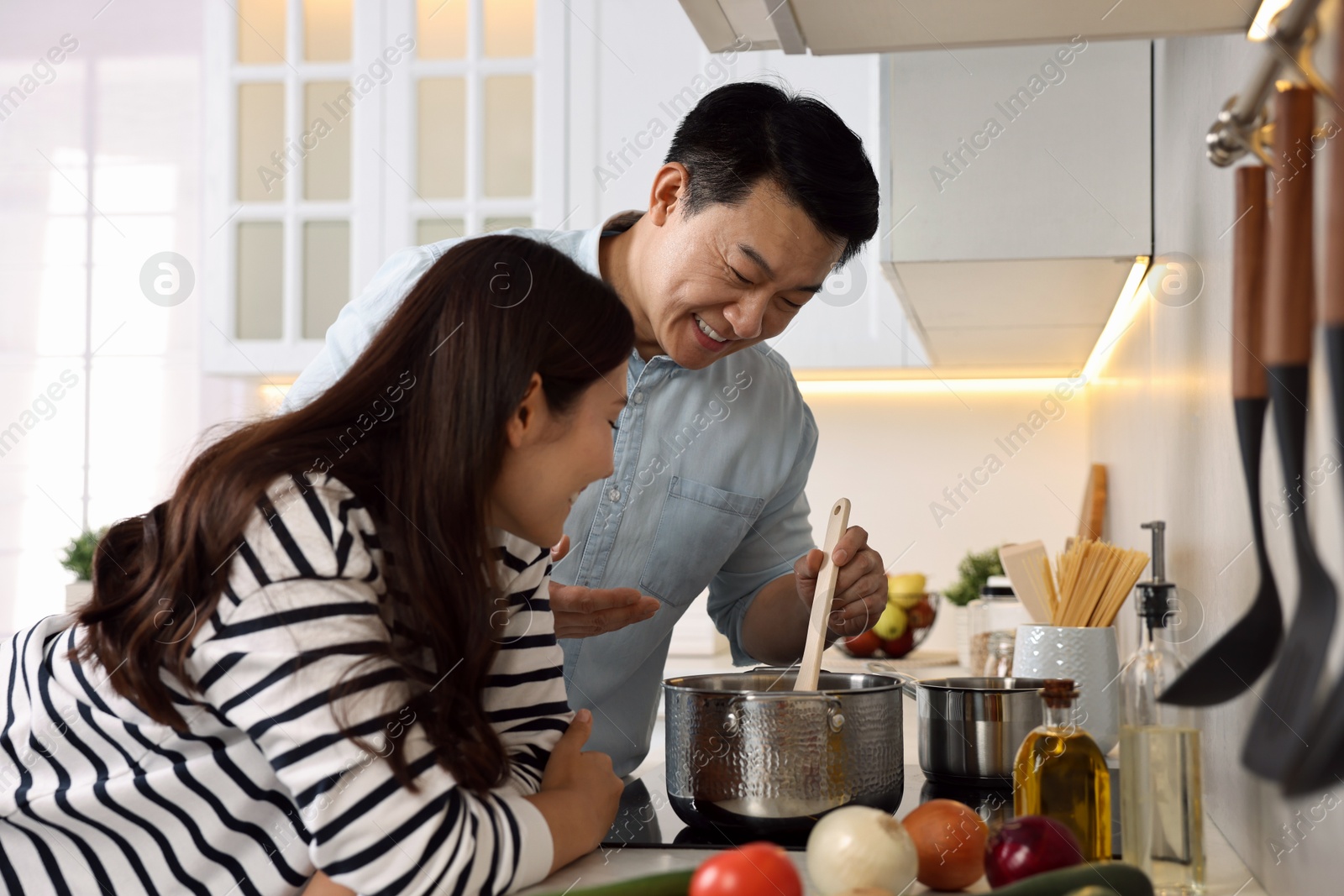 Photo of Happy lovely couple cooking together in kitchen