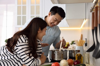 Happy lovely couple cooking together in kitchen